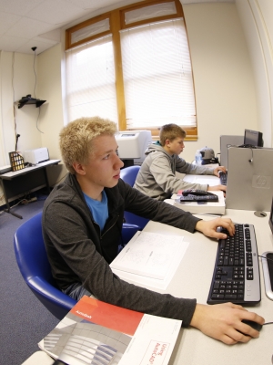 one student uses a computer to engage with distance learning classmates