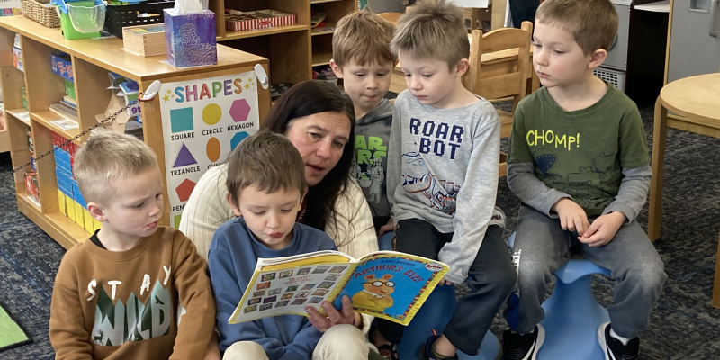 Teacher reading a book with a small group of children